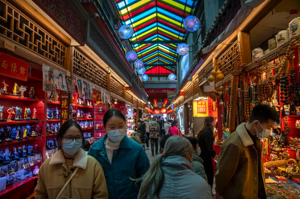 La gente mira las tiendas que venden baratijas y recuerdos a lo largo de una calle comercial turística en Beijing en febrero de 2023. La recuperación de los viajes aéreos en China después del Covid ha sido relativamente lenta. Foto: AP