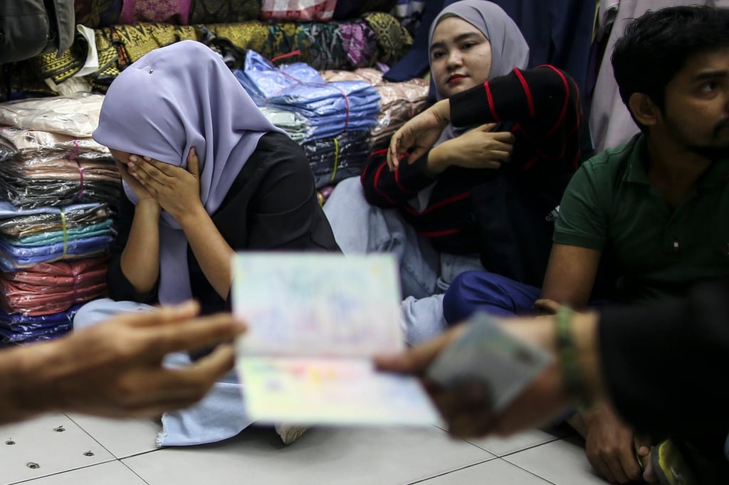 Detainees react during an immigration raid at a clothing store Malaysia on August 15. Photo: EPA-EFE Detainees react during an immigration raid at a clothing store Malaysia on August 15. Photo: EPA-EFE