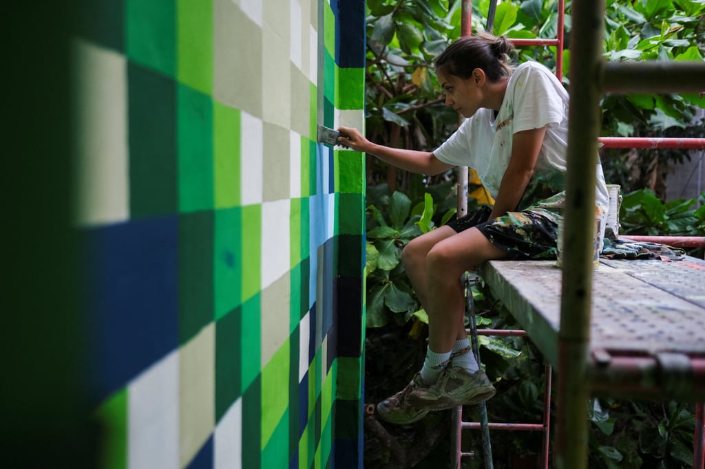 Italian artist Beatrice Vigoni paints a building as part of the project. Photo: Reuters Italian artist Beatrice Vigoni paints a building as part of the project. Photo: Reuters