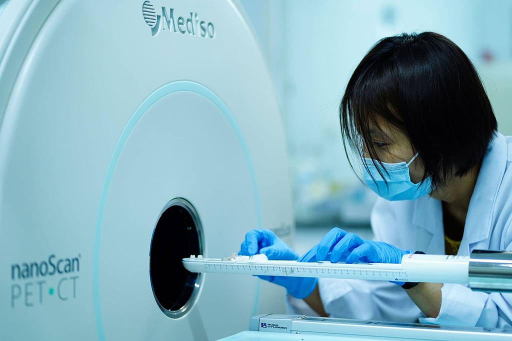 A researcher from a lab at Peking University uses a machine to visualise engineered radioligands distributed in mice tumour cells. Improvements to a type of radiation therapy could offer hope to late-stage cancer patients. Photo: Peking University