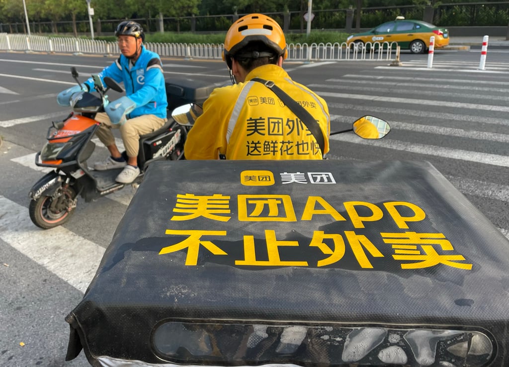 A food delivery courier of Meituan, right, crosses paths with an Ele.me rider in Beijing. Photo: Simon Song