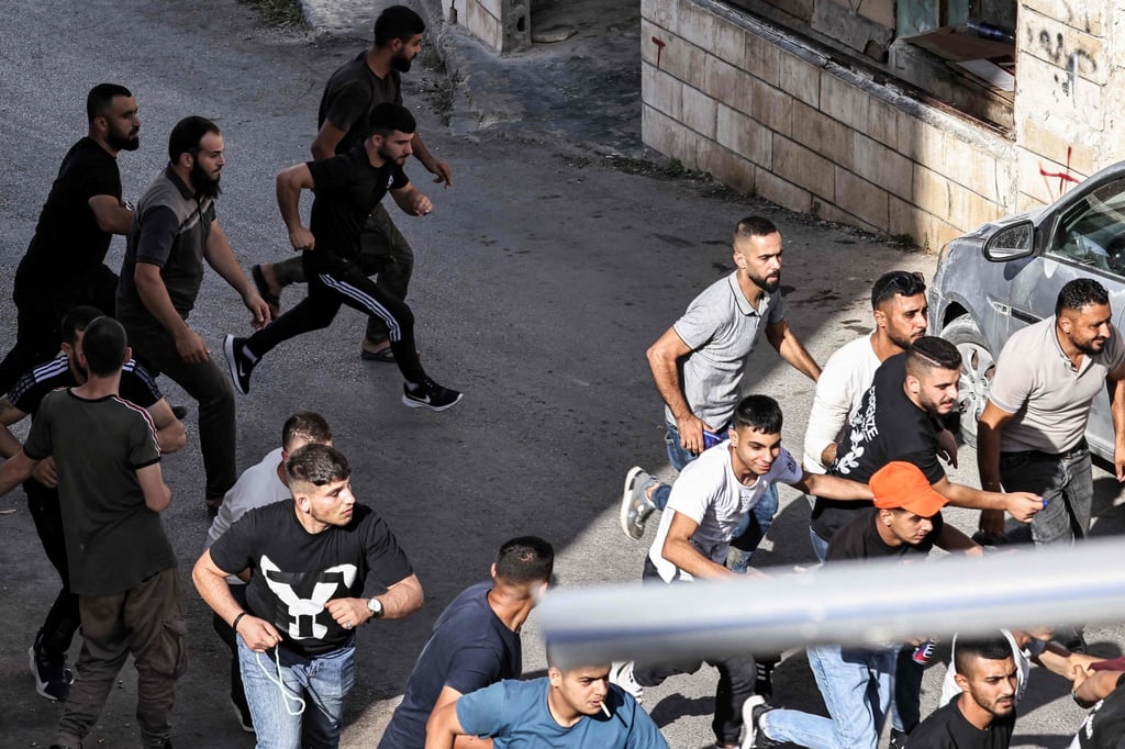 Palestinian men run for cover during an Israeli army raid in Qabatiyah. Photo: AFP Palestinian men run for cover during an Israeli army raid in Qabatiyah. Photo: AFP