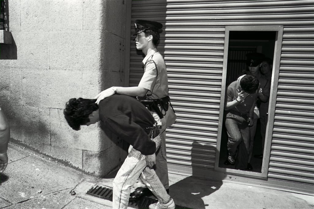 Two men charged with the robbery are escorted from Western Court. Photo: SCMP Archive