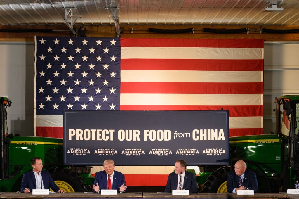 Behind Donald Trump were large green tractors and a sign declaring ‘Protect our food from China’. Photo: Bloomberg Behind Donald Trump were large green tractors and a sign declaring ‘Protect our food from China’. Photo: Bloomberg