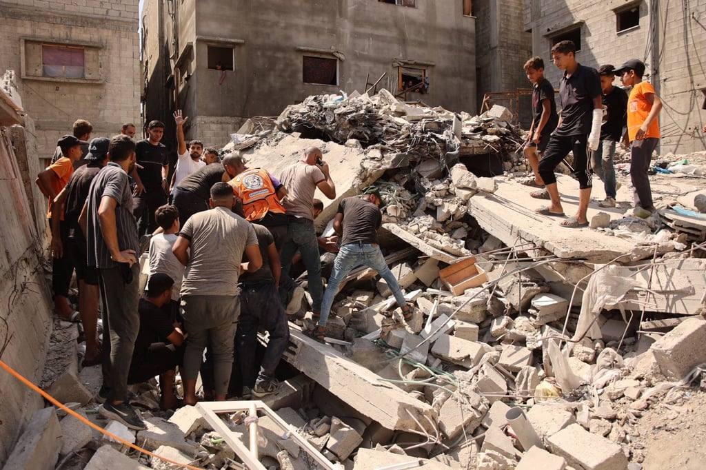 Palestinians search for survivors amid the rubble of a building in Gaza City. Photo: AFP