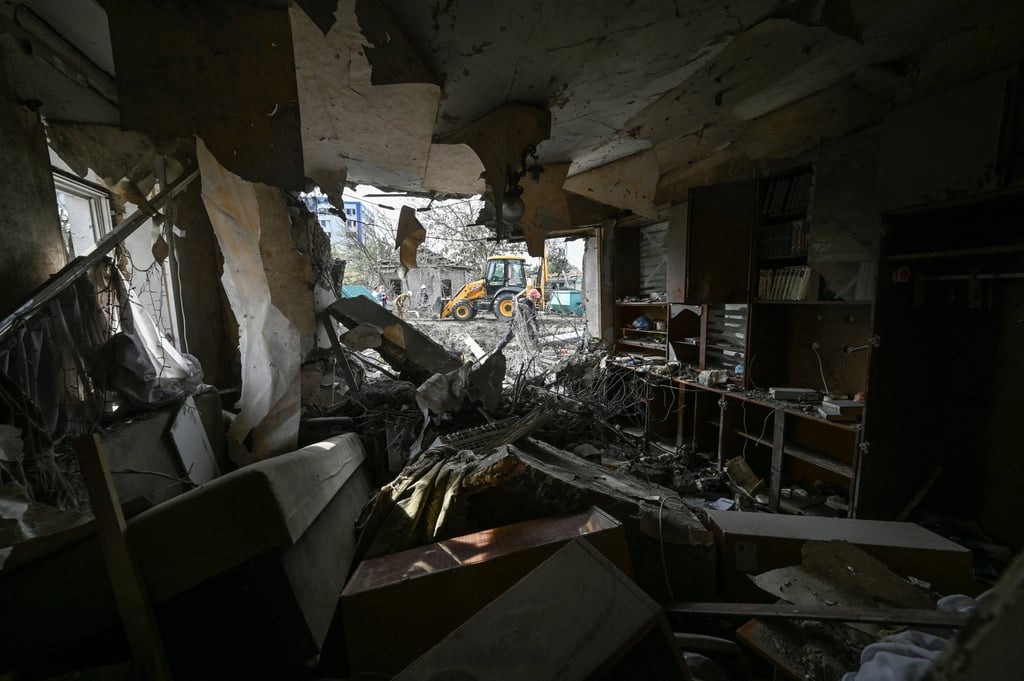 A rescuer removes debris at a site of a residential area heavily damaged by a Russian air strike in Zaporizhzhia. Photo: Reuters