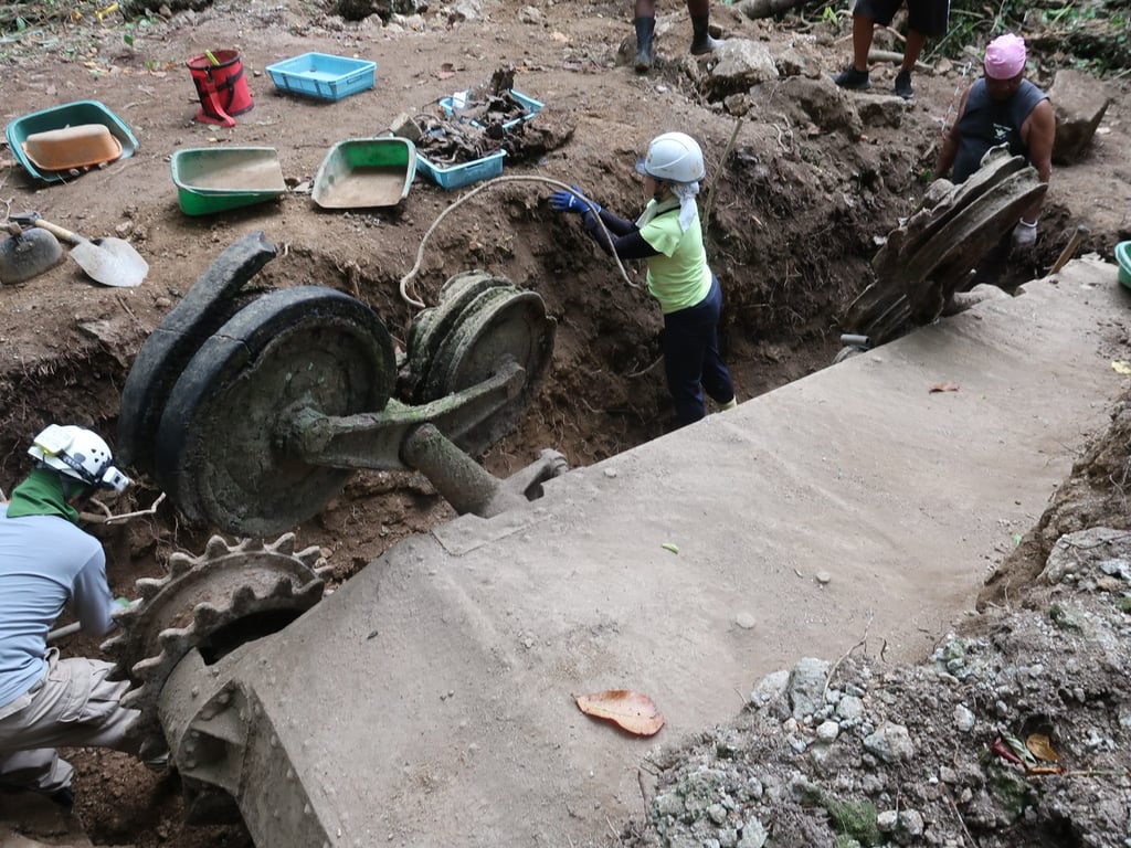 Toshiko Kido (in green) helps excavate the light tank that she hopes may contain her grandfather’s remains. Photo: Julian Ryall Toshiko Kido (in green) helps excavate the light tank that she hopes may contain her grandfather’s remains. Photo: Julian Ryall