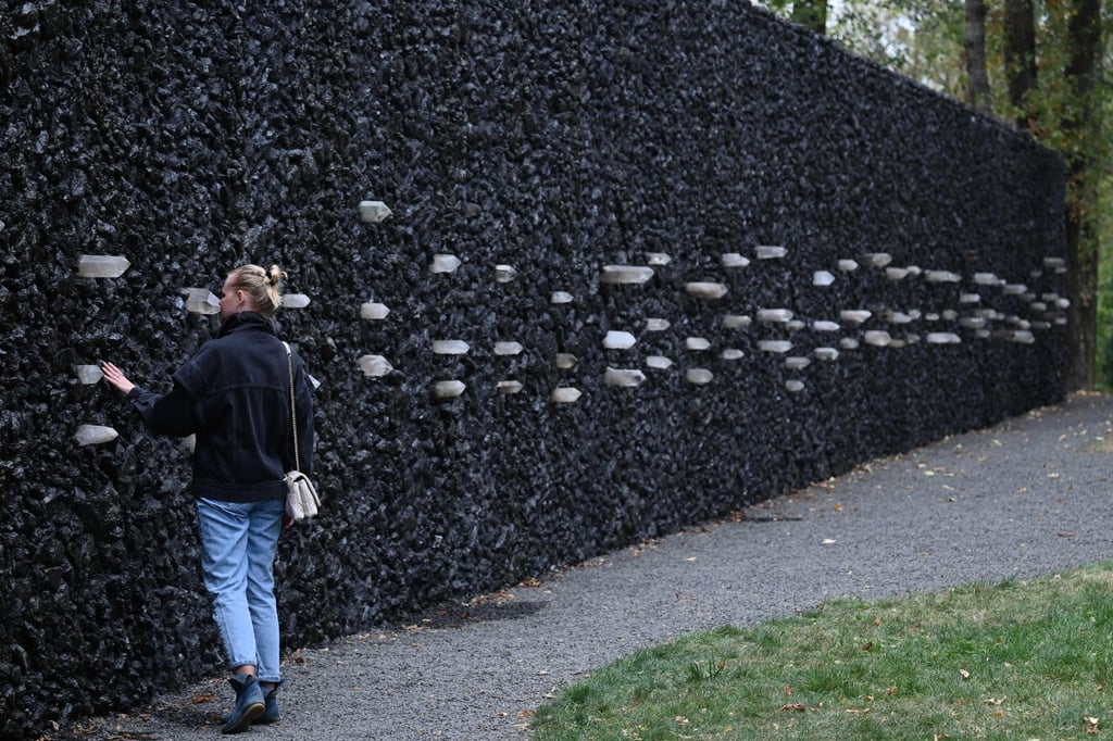 A woman prays at the Crystal Wall of Crying in the Babyn Yar memorial. Photo: AFP A woman prays at the Crystal Wall of Crying in the Babyn Yar memorial. Photo: AFP