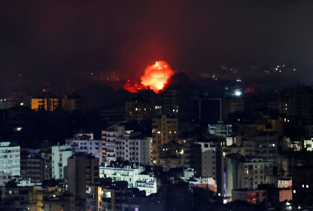 Fire and smoke rise over Beirut’s southern suburbs after a strike early Thursday. Photo: Reuters