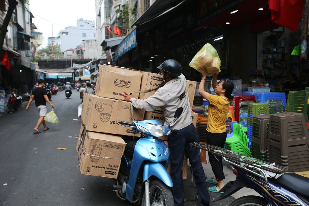 People load goods onto a motorbike at a market in Hanoi. File photo: EPA-EFE People load goods onto a motorbike at a market in Hanoi. File photo: EPA-EFE
