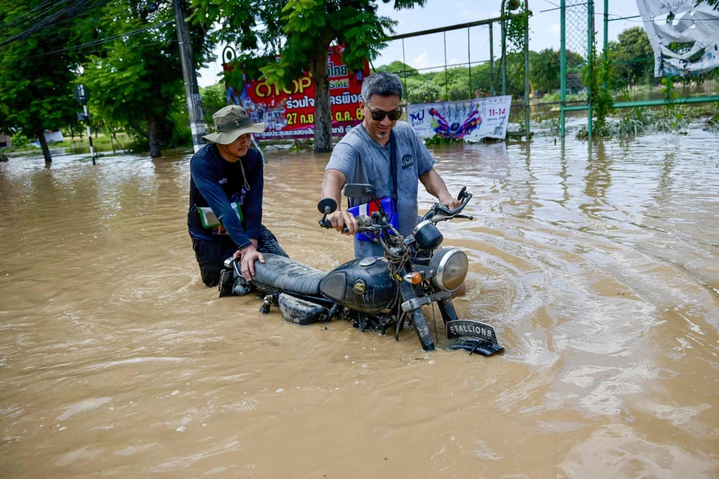 Residents transport their motorbike through a flooded street in Chiang Mai on Sunday. Thailand’s northern provinces have been hit by large floods since Typhoon Yagi struck the region in early September, with one district reporting its worst floods in 80 years. Photo: AFP