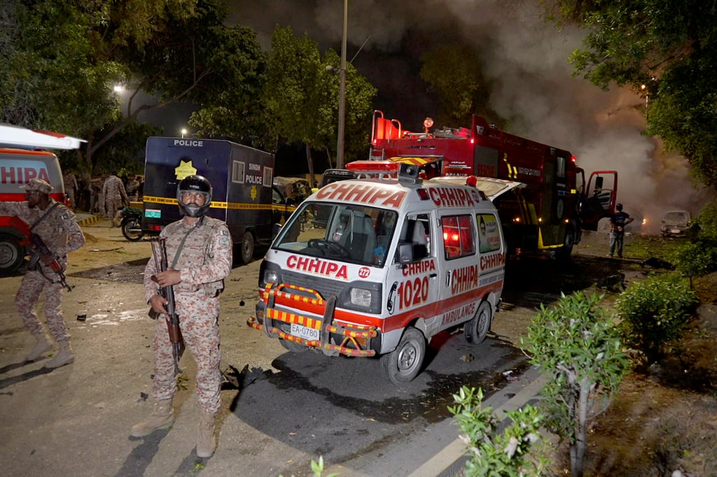 Paramilitary soldiers stand guard close to the site of an explosion outside Karachi airport, Pakistan on Sunday. Photo: AP