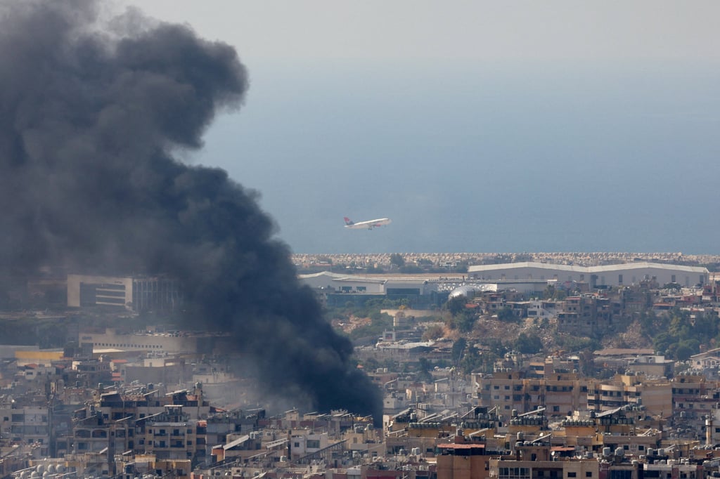 Smoke rises in Beirut’s southern suburbs after a strike, as a plane takes off from Rafic Hariri International Airport. Photo: Reuters Smoke rises in Beirut’s southern suburbs after a strike, as a plane takes off from Rafic Hariri International Airport. Photo: Reuters