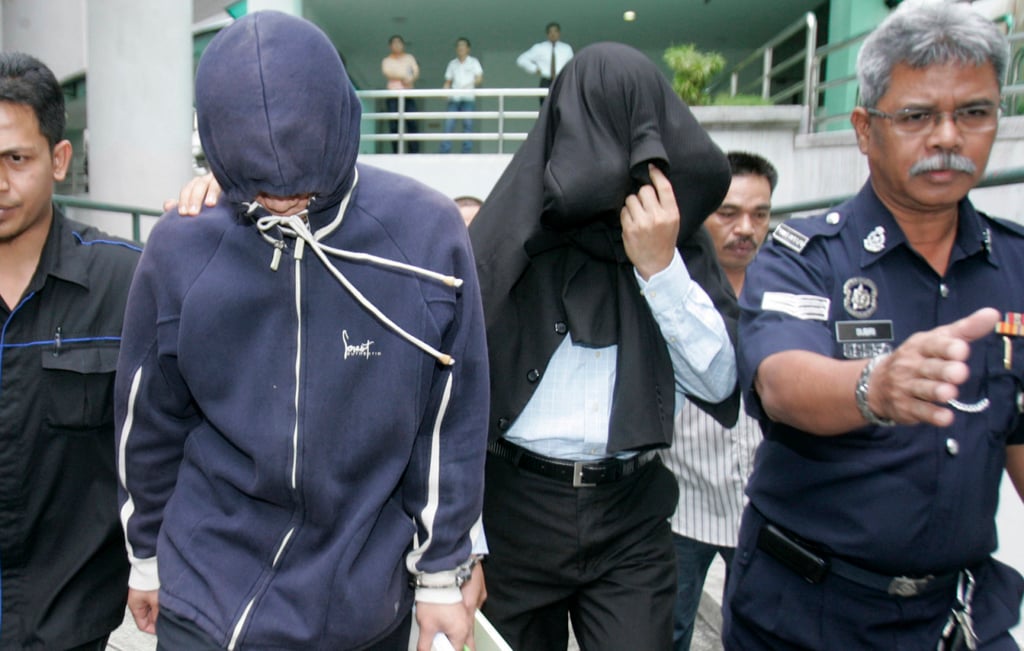 Azilah Hadri and Sirul Azhar Umar arrive at a courthouse in Shah Alam, outside Kuala Lumpur. with their faces covered in 2009. Photo: Reuters Azilah Hadri and Sirul Azhar Umar arrive at a courthouse in Shah Alam, outside Kuala Lumpur. with their faces covered in 2009. Photo: Reuters