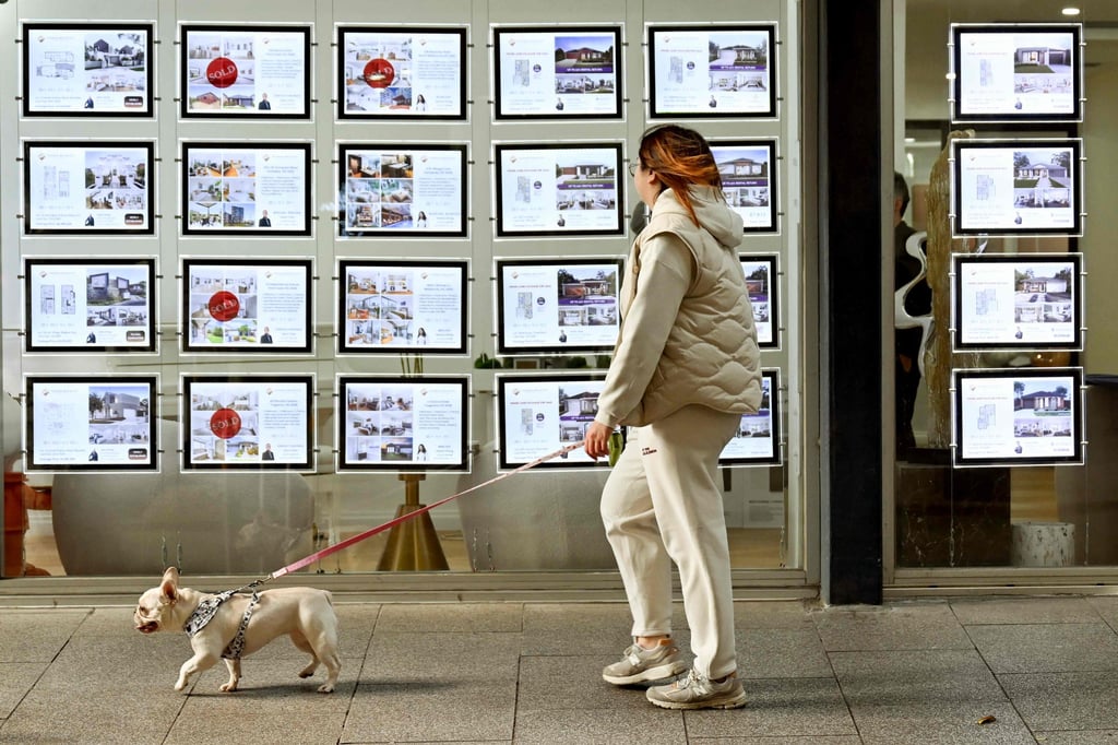 A woman and her dog walk past a property agents display in Melbourne. Among almost 1 million women who experienced stalking by a male in the last 10 years in Australia, 78 per cent were stalked by a male they knew. Photo: AFP A woman and her dog walk past a property agents display in Melbourne. Among almost 1 million women who experienced stalking by a male in the last 10 years in Australia, 78 per cent were stalked by a male they knew. Photo: AFP
