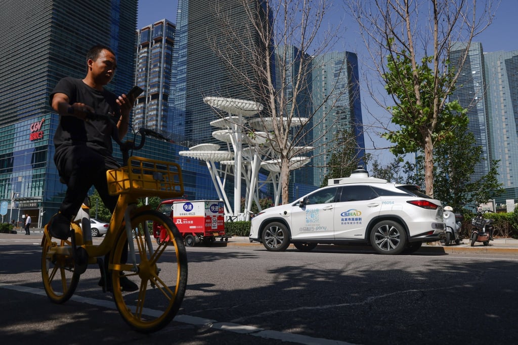 A man rides his bike beside a self-driving taxi in Daxing district in Beijing, September 2, 2024. Photo: EPA-EFE A man rides his bike beside a self-driving taxi in Daxing district in Beijing, September 2, 2024. Photo: EPA-EFE