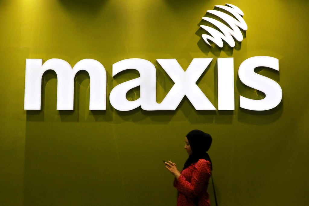 A woman walks past a logo of Maxis at its headquarters in Kuala Lumpur, Malaysia. Photo: Reuters A woman walks past a logo of Maxis at its headquarters in Kuala Lumpur, Malaysia. Photo: Reuters