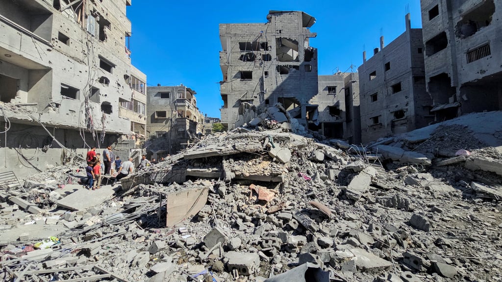 Palestinians gather at the site of Israeli strikes on houses and residential buildings in Beit Lahiya, northern Gaza on Sunday. Photo: Reuters