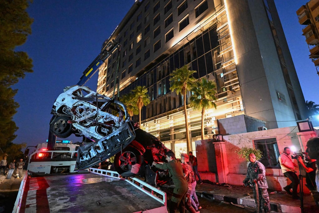 Syrian emergency and security services inspect the wreckage of a car that exploded in Damascus on Monday. Photo: AFP