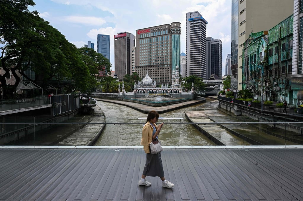 A woman checks her mobile phone in central Kuala Lumpur. Photo: AFP