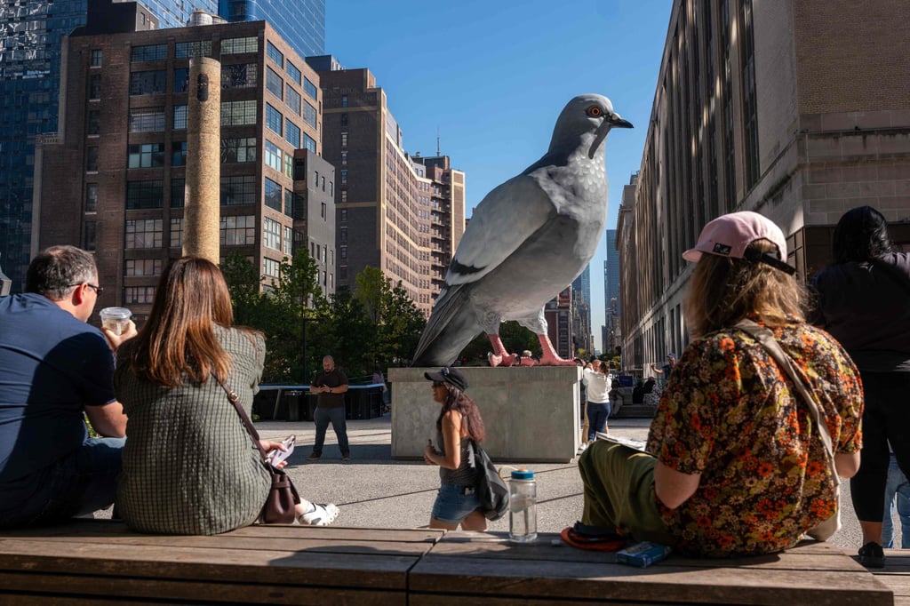 Pessoas relaxam em frente à estátua em 21 de outubro de 2024. Foto: Getty Images via AFP