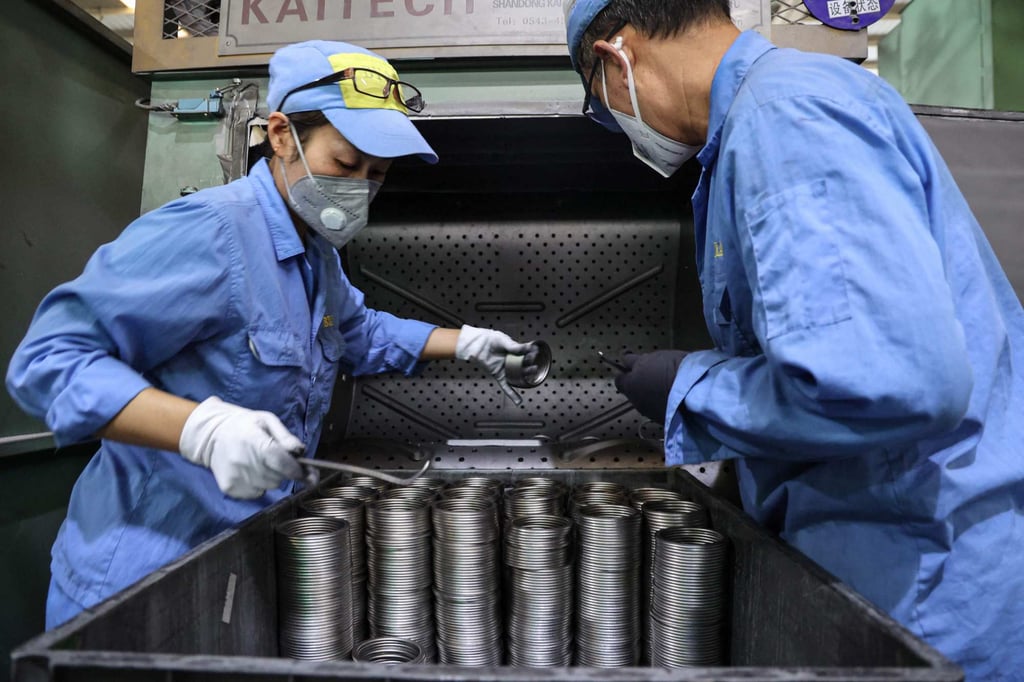 Employees work on aluminium piston rings at a car parts factory in Binzhou, in eastern China’s Shandong province. Photo: AFP Employees work on aluminium piston rings at a car parts factory in Binzhou, in eastern China’s Shandong province. Photo: AFP