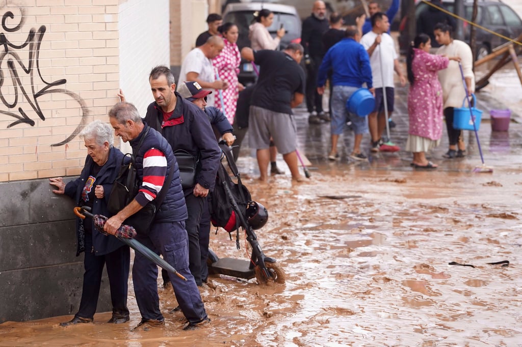 People walk through flooded streets. Photo: AP People walk through flooded streets. Photo: AP