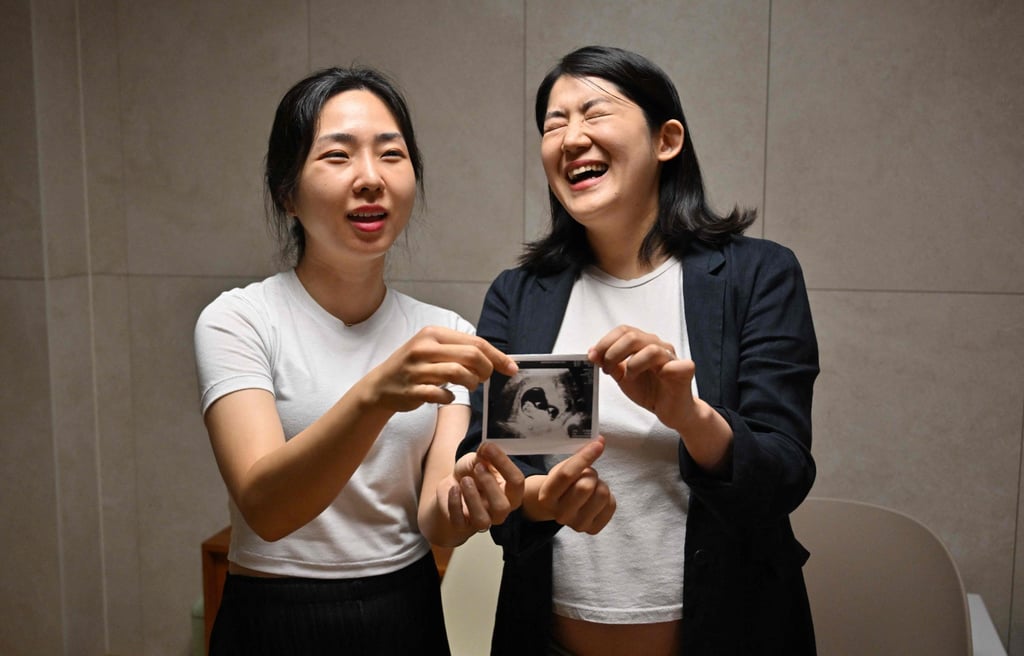 Kim Kyu-jin (right) and her wife, Kim Sae-yeon, hold an ultrasound image of their unborn daughter at their home in Seoul. Photo: AFP
