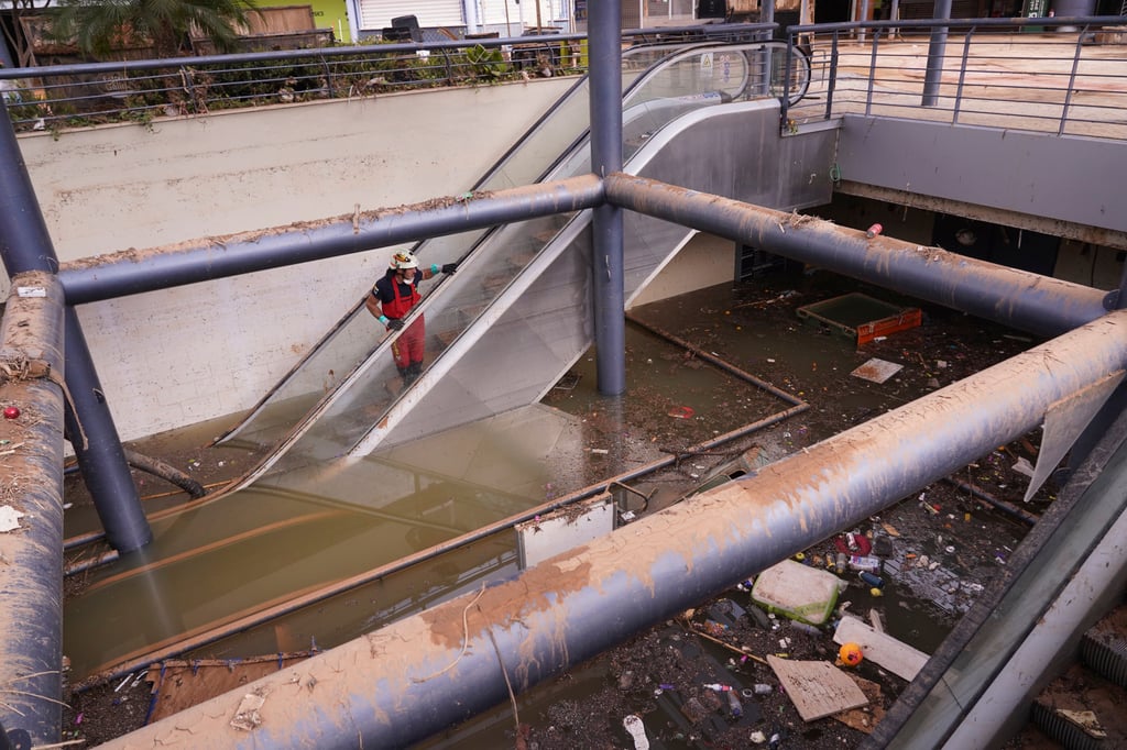 A firefighter looks at damage in a shopping centre on Monday after last week’s fatal floods on the outskirts of Valencia. Photo: AP