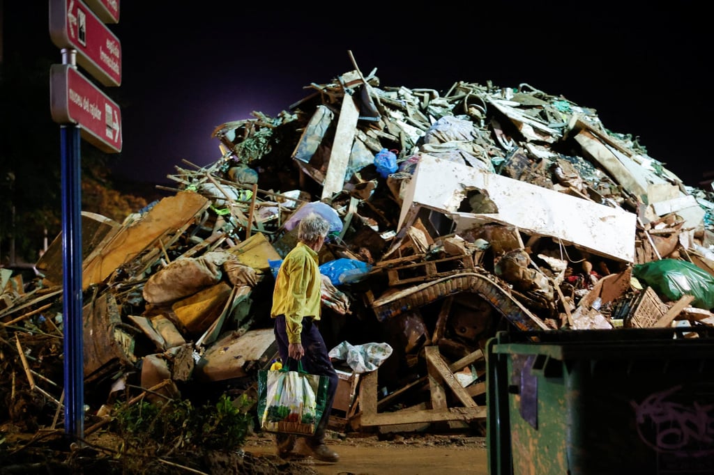 A person walks next to mud-covered debris following heavy rains that caused floods, near Valencia, Spain, on November 4. Photo: Reuters