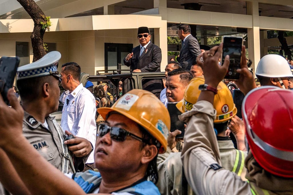Indonesians in Jakarta use their mobile phones to take selfies as President Prabowo Subianto (centre) rides past last month. Photo: AFP Indonesians in Jakarta use their mobile phones to take selfies as President Prabowo Subianto (centre) rides past last month. Photo: AFP