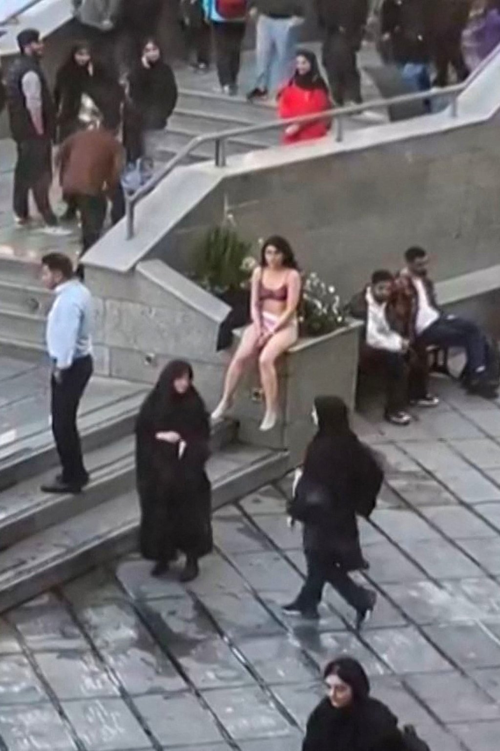 A female student sits in her underwear outside Tehran’s Islamic Azad University, in footage shared on social media. Photo: UGC via AFP