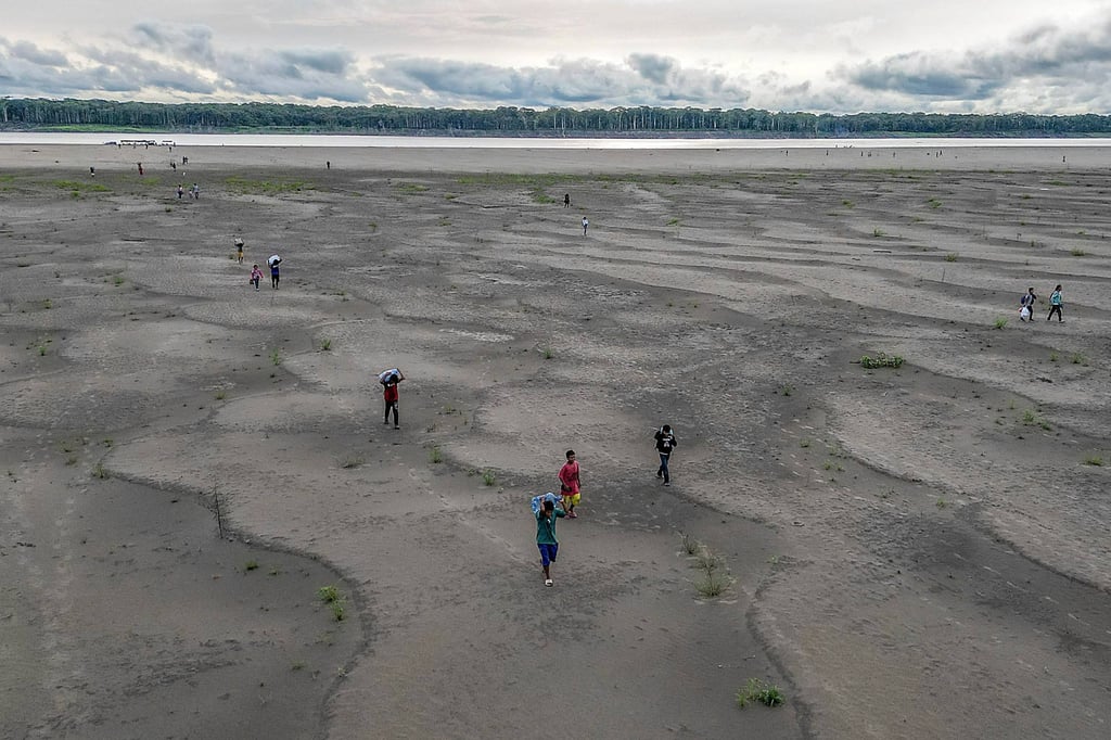 Yagua Indigenous people carrying water and other goods due to the low level of the Amazon river at Isla de los Micos, Amazonas department, Colombia, on October 4. More than 420,000 children in the Amazon basin are being badly affected by a drought parching much of South America that is impacting water supplies and river transport, Unicef said on November 6. Photo: AFP