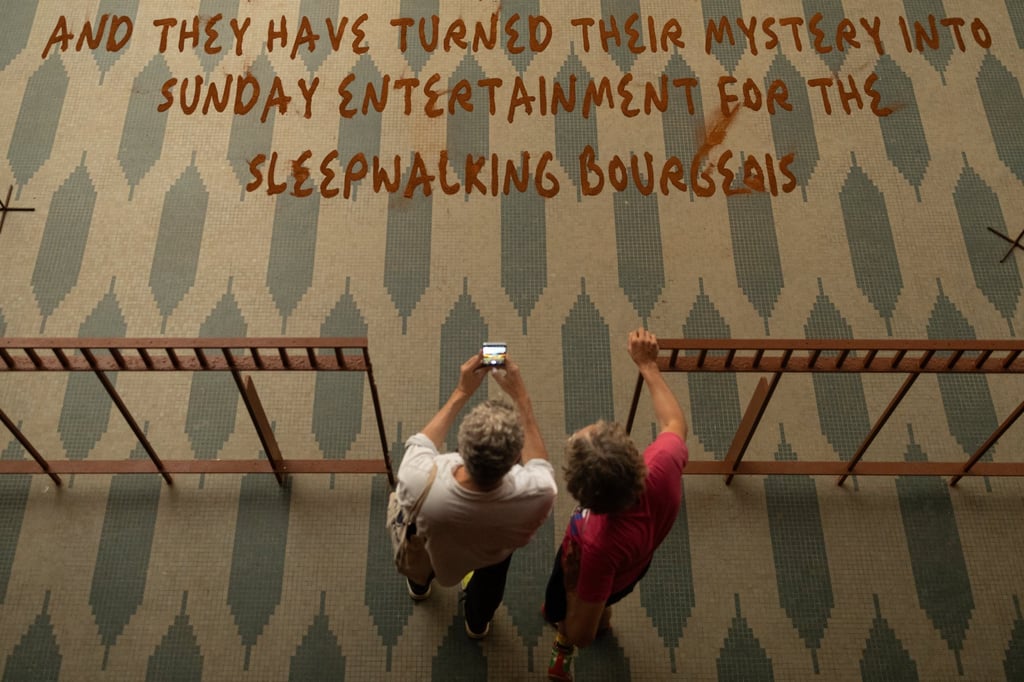 Visitors photograph part of the installation A Palace in Pieces including Mountain Mama by Kenyan artist Wangechi Mutu. Photo: EPA-EFE