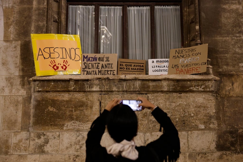 A person takes pictures of protest signs left at Valencia’s regional government headquarters as thousands of called for the resignation of Valencia’s rulers due to the management of the floods in the province. Photo: EPA-EFE