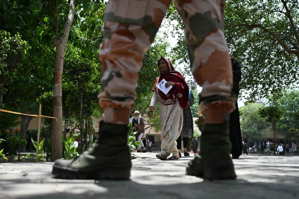 A voter walks past a security personnel after casting her ballot at a polling station in India’s Ghaziabad. Photo: AFP