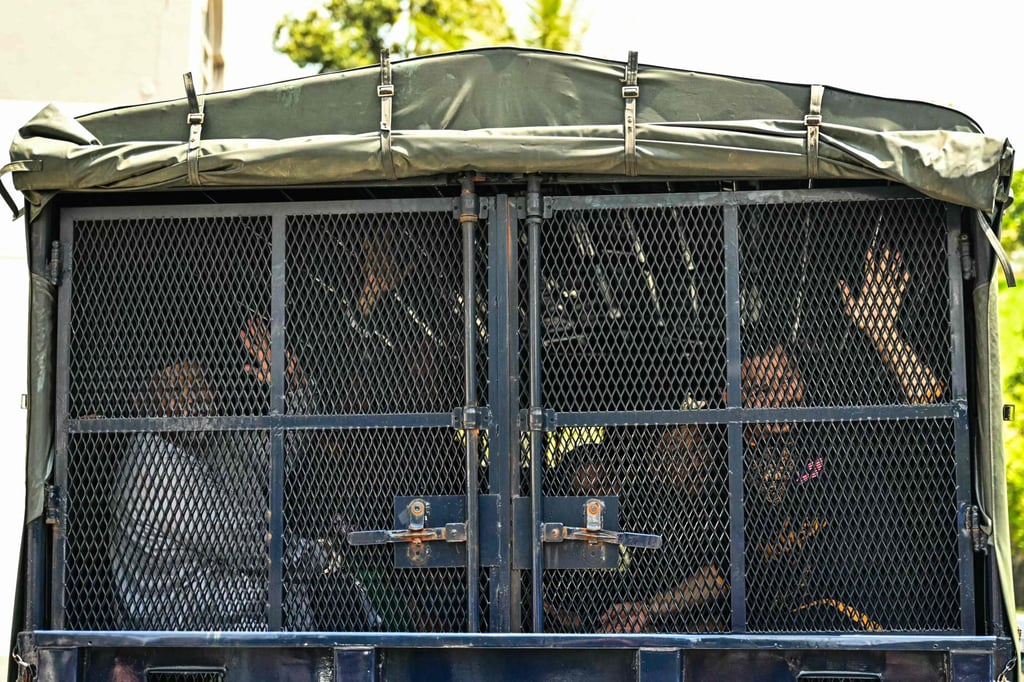 GISB CEO Nasiruddin Mohd Ali (left) and other members wave to their family from a police vehicle as they leave the Magistrate Court in Selayang. Photo: AFP