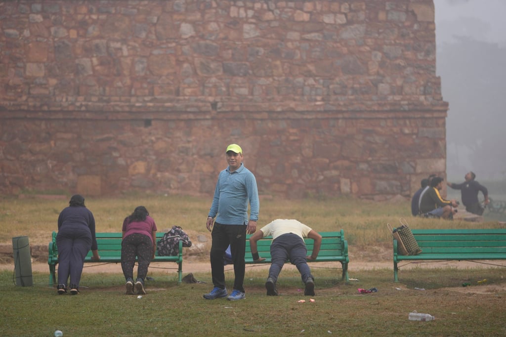 Yoga teacher Ajay Chowdhary, 51, stands beside his students, surrounded by smog in Lodhi Garden in New Delhi. Photo: AP
