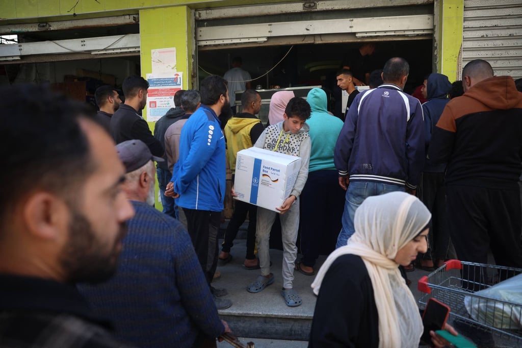 People queue to receive humanitarian aid in the central Gaza Strip. Photo: AFP