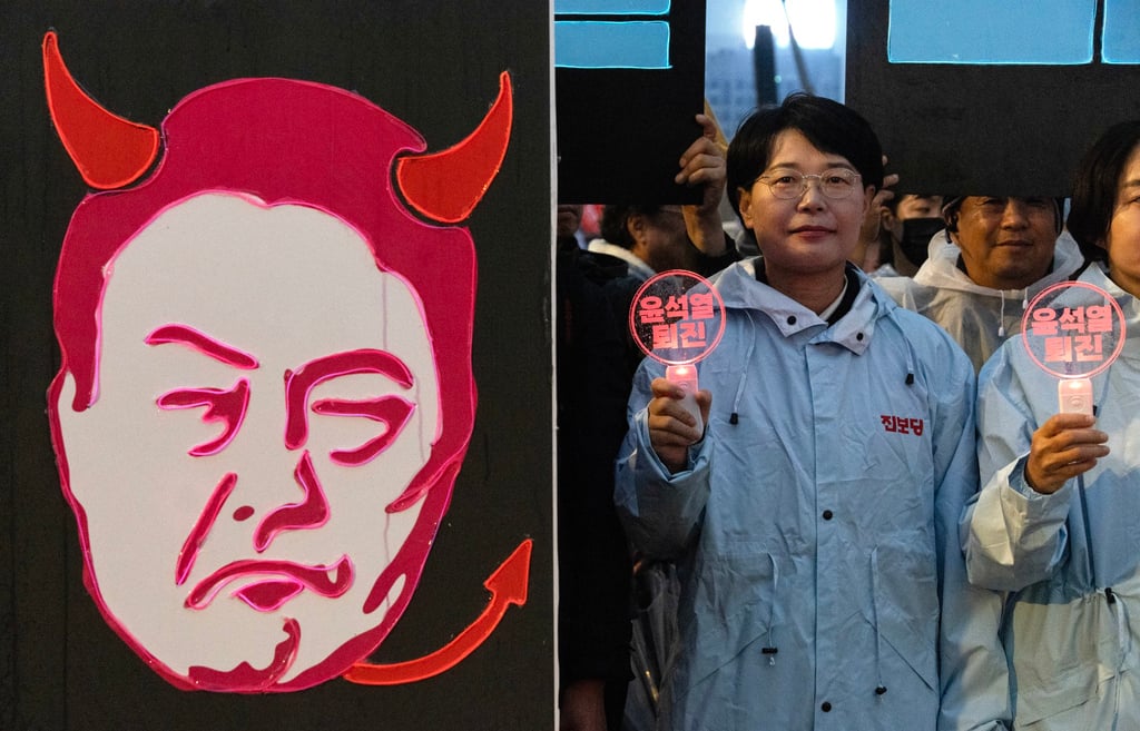 Protesters rally in Seoul on Saturday carrying a banner depicting Yoon Suk-yeol and calling for the South Korean president’s resignation. Photo: EPA-EFE