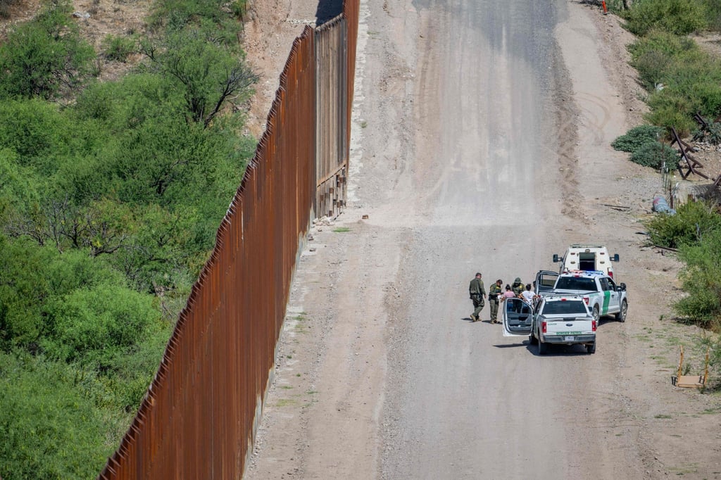 A group of migrants is apprehended by border officers after crossing into the US earlier this year. Photo: AFP