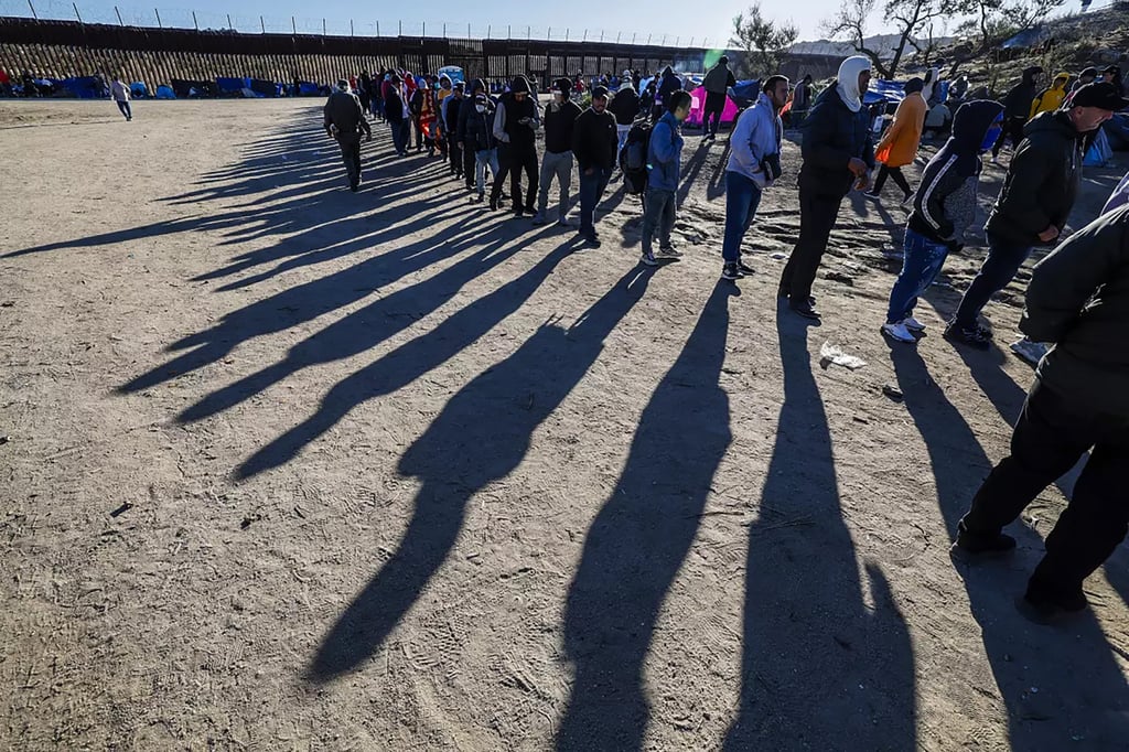 Migrants queue up for food provided by volunteers at a makeshift camp near the border wall in Jacumba, California. Photo: Los Angeles Times / TNS Migrants queue up for food provided by volunteers at a makeshift camp near the border wall in Jacumba, California. Photo: Los Angeles Times / TNS