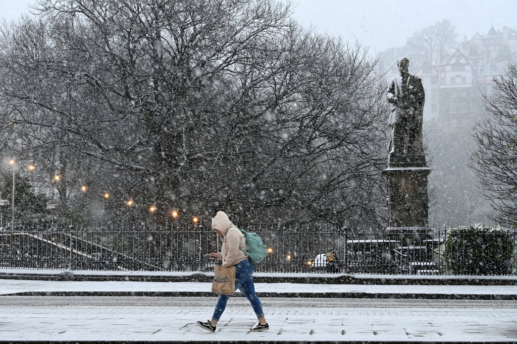 A person walks amidst snowfall during Storm Bert, along Princes Street in Edinburgh, Scotland. Photo: Reuters