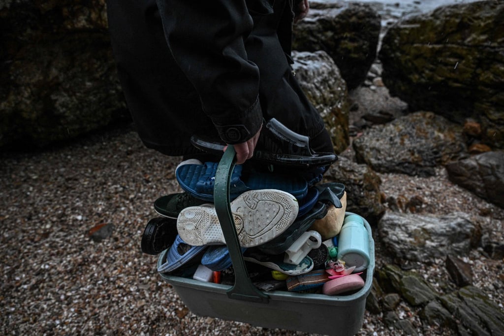 Artist Fu Junsheng holding a basket of plastic waste including lighters, slippers, children’s toys and cosmetics containers. Photo: AFP Artist Fu Junsheng holding a basket of plastic waste including lighters, slippers, children’s toys and cosmetics containers. Photo: AFP