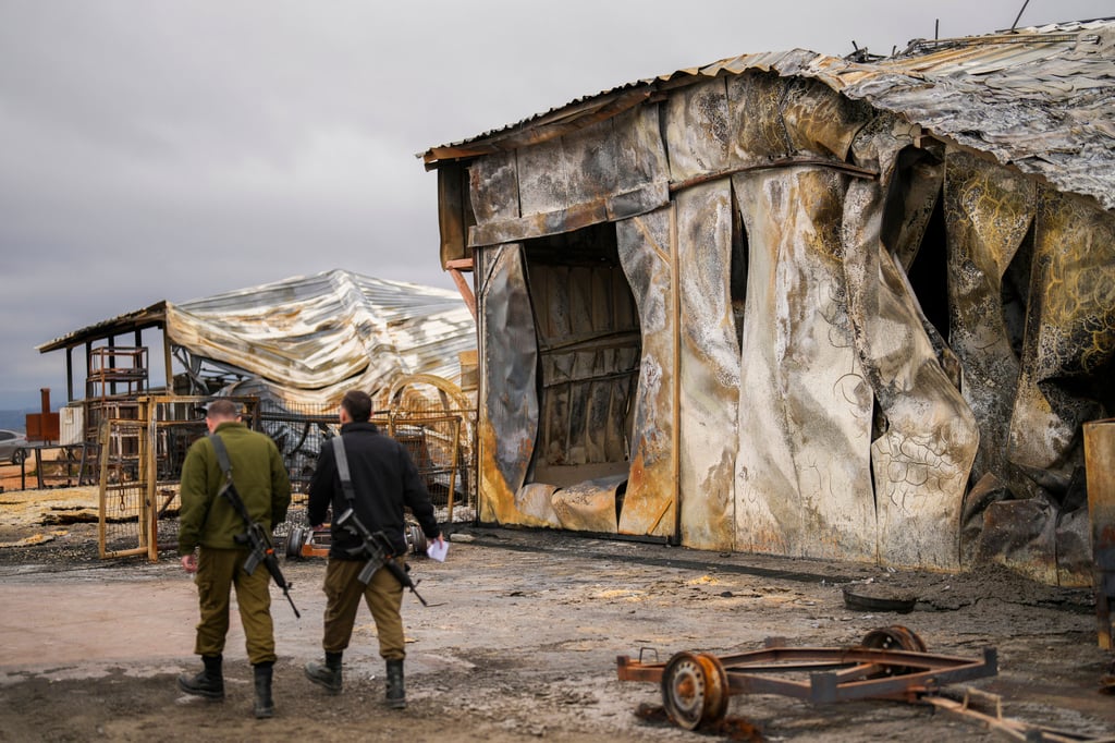 Israeli soldiers walk next to a damaged farm hit by a rocket fired from Lebanon in Avivim, northern Israel, near the border with Lebanon on Wednesday. Photo: AP Israeli soldiers walk next to a damaged farm hit by a rocket fired from Lebanon in Avivim, northern Israel, near the border with Lebanon on Wednesday. Photo: AP