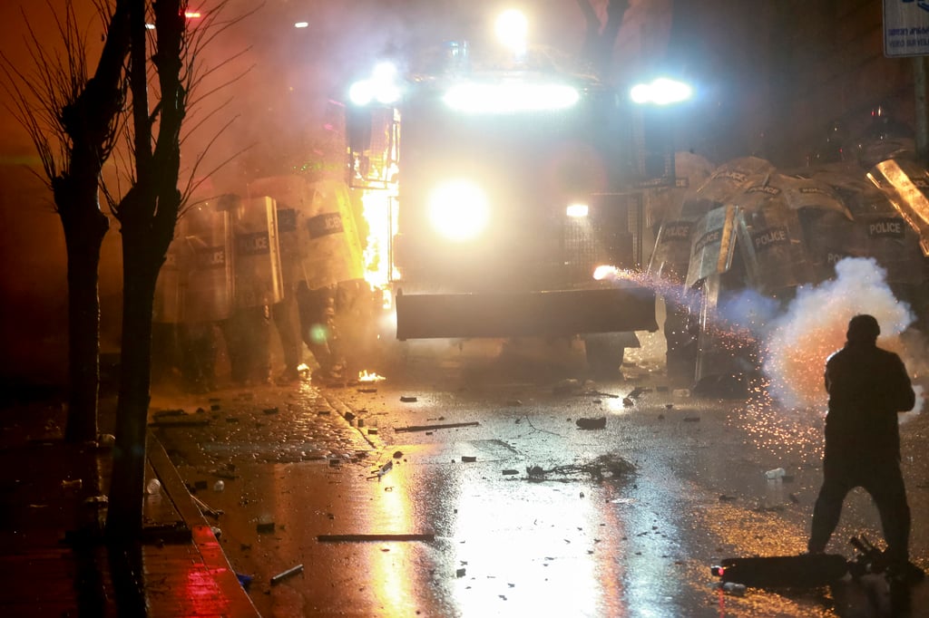 A demonstrator uses firecrackers against police. Photo: AP A demonstrator uses firecrackers against police. Photo: AP