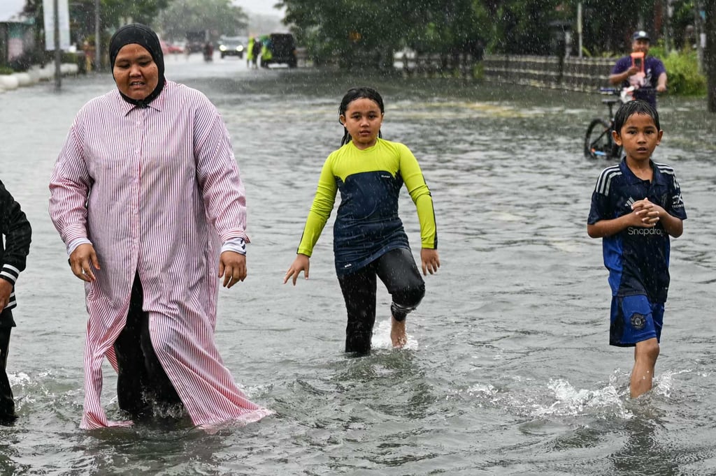 Residents wade through flood waters on a street in Pasir Puteh, Malaysia’s Kelantan state, on Saturday. Photo: AFP Residents wade through flood waters on a street in Pasir Puteh, Malaysia’s Kelantan state, on Saturday. Photo: AFP
