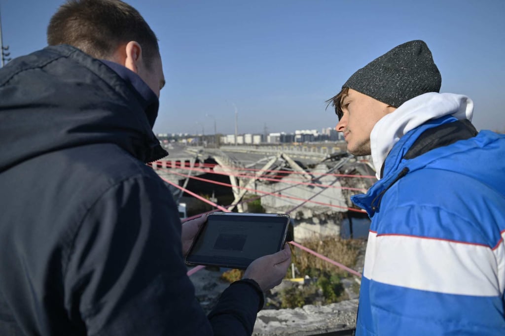 Ukrainian tour guide Oleksiy Goryachev shows Blasco Ventas the destroyed Irpin bridge, near Kyiv. Photo: AFP