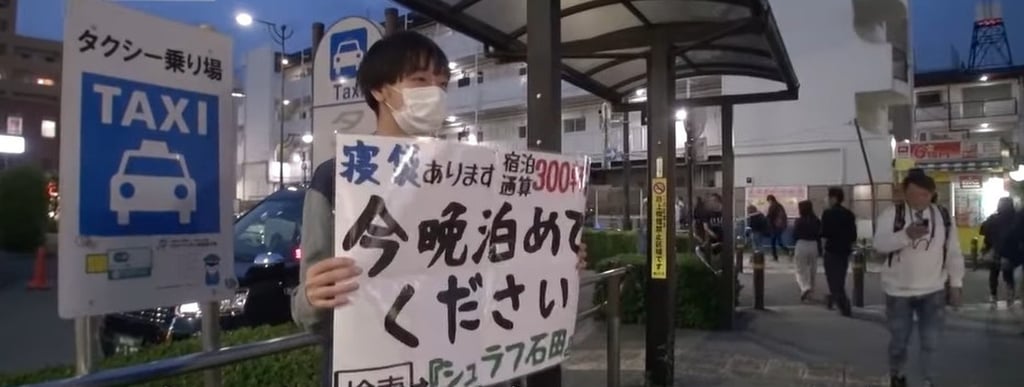 Ishida often spends hours at train stations or busy streets, holding a sign to find free accommodation. Photo: Baidu