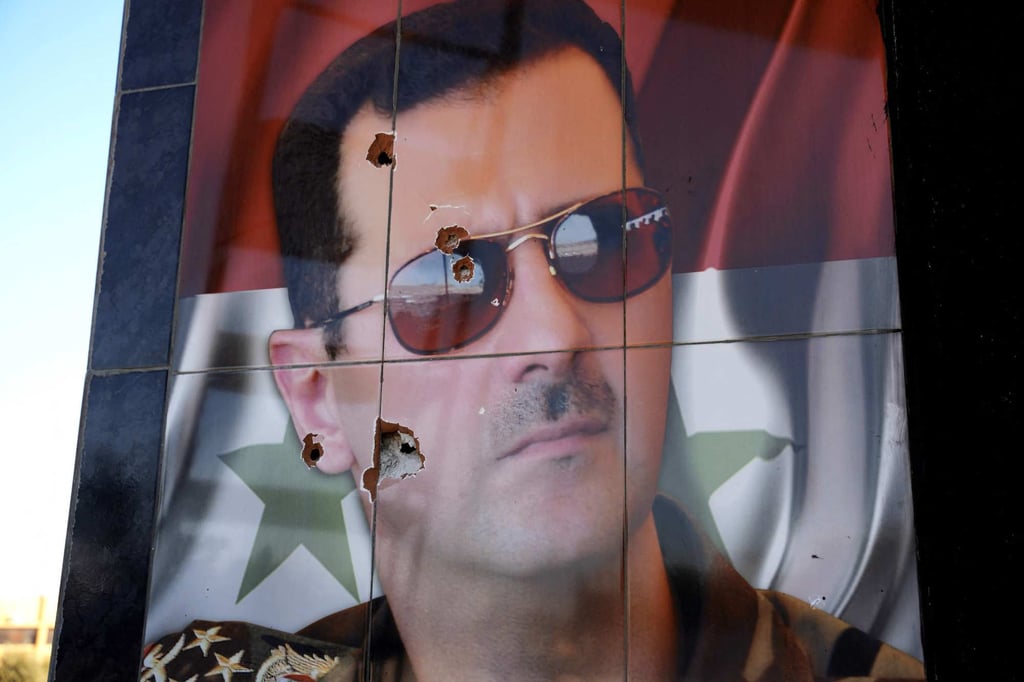 A bullet-riddled portrait of Syrian President Bashar al-Assad is seen the Kweyris military airfield. Photo: AFP